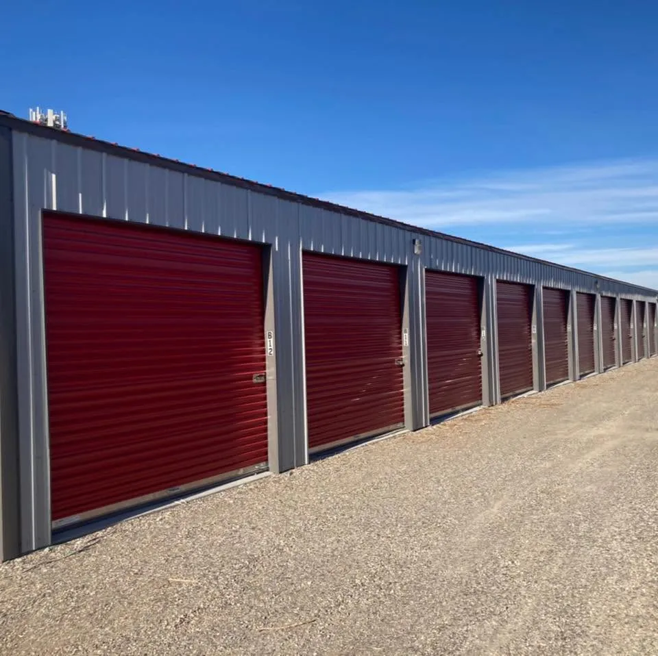 Numbered storage unit doors along the gravel drive aisle